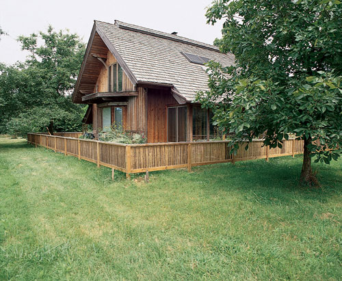 The 1,500-square-foot home faces east, following the mandates of ancient Indian sthapatya ved building. John and Caree Connet later encircled it with a bamboo “Vastu fence,” another sthapatya ved requirement. Strong cross-ventilation and large roof overhangs negate the need for air conditioning, while the glass window wall on the south side provides 50 to 60 percent of the home’s heat through passive solar in winter. The long, low cupola on the roof, called a Boston Ridge, provides a cushion of air that intercepts heat in summer and keeps the surface cool in winter, allowing snow to insulate and seal the roof.